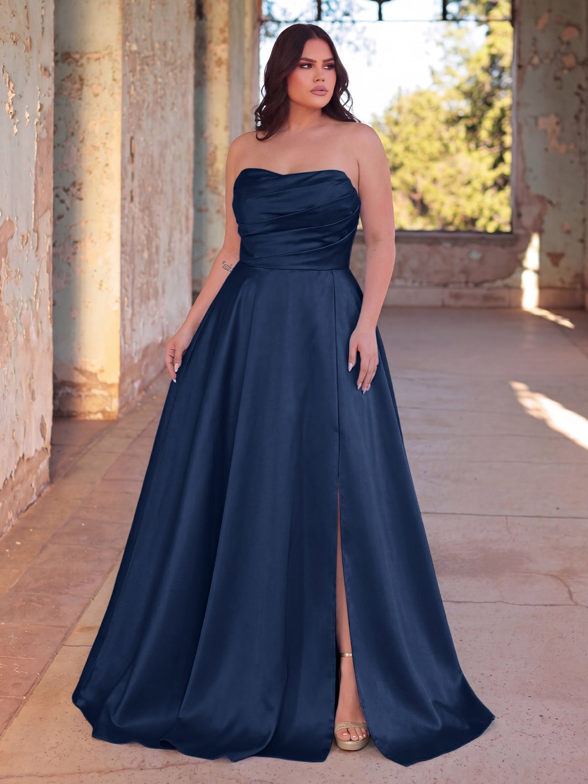 Full-length front view of a navy blue strapless satin A-line gown with high slit